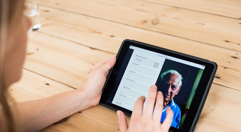 Person with a tablet browsing a donation page