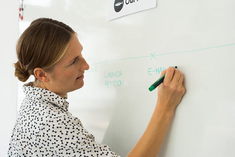 Mobiliser writing a mobilisation plan on the white board for OurFish